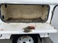 A 2015 Ford F-550 with an open compartment showing a dirty interior and a red tool attached to a switch inside the compartment