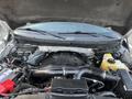 A 2014 Ford F-150 engine compartment showing the V8 engine with various components including a battery reservoir and air intake system
