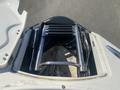 A 2013 Larson 238 boat hatch showing a closed compartment with metal hydraulic supports and a ladder retracting mechanism