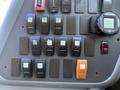 Close-up of control panel buttons in a 2013 International CE300 including toggle switches and an electronic display