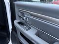The interior door panel of a 2018 RAM 5500 featuring a silver door handle power window controls and a textured gray finish