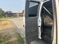 A white 2021 Chevrolet Express van with an open side door revealing a spacious interior and seating.