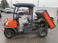 A 2010 Kubota RTV 900 utility vehicle with an orange and black exterior open cargo bed and two seats in the front