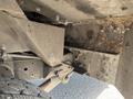 Close-up view of the undercarriage of a 2012 Ford Econoline showing metal components and signs of wear and debris accumulation