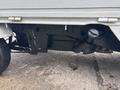 A 2010 Suzuki Carry showing the undercarriage with visible suspension components and exhaust system