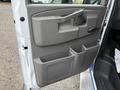 The interior door panel of a 2019 Chevrolet Express with a handle a lock button and storage compartments