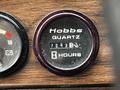 Hobbs quartz hour meter showing 7263.1 hours on a wooden panel with additional gauges for battery and oil pressure