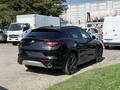 A black 2020 Alfa Romeo Stelvio SUV with a sporty design and sleek curves is displayed prominently in the foreground