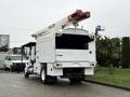A 2020 International MV607 utility truck with a rear-mounted aerial lift and a white body, featuring a closed rear compartment and lights on the back
