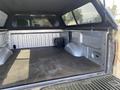 A 2014 Ford F-150 with an open truck bed showing a lined interior and storage compartments on the sides