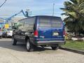 A blue 2013 Ford E-350 Super Duty van parked with a high roof and four wheels visible