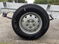 A close-up of a wheel on a 2023 RAM Promaster 3500 featuring a silver rim and a black tire with the brand name Roadian CT8 written on it