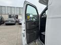 A 2020 Chevrolet Express van with an open driver's door revealing the interior including the dashboard and side mirror