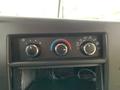 Dashboard controls of a 2015 Chevrolet Express featuring three dials for climate control and air circulation without any visible buttons or screens