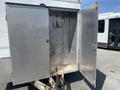 A 2008 Wells Industries Inc EW1422 trailer with an open diamond-plate storage compartment showing hooks inside