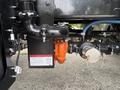 Close-up view of a 2025 Peterbilt 536 engine component showcasing pipes fittings and an orange turbocharger assembly