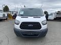 A white 2017 Ford Transit van facing forward with a blue lower front bumper and hood vents