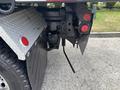 A 2013 Kenworth T370 showing the rear section with reflective lights and mud flaps attached on either side of the truck's body