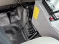 A gear shift knob in a 2007 Ford F-550 with a textured black base and several gears indicated on the knob itself