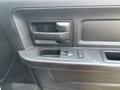 The interior door panel of a 2013 RAM 5500 featuring a door handle a window control panel and a slot for storage