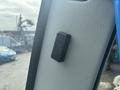 A black switch mounted on a textured white surface of a vehicle interior