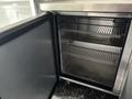 A 2020 Freightliner MT45 vehicle with an open storage compartment showcasing metal shelves inside