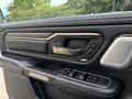 Interior door handle and control panel of a 2021 RAM 1500 featuring buttons for window controls and seat adjustments