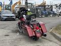 A 2009 Harley-Davidson Road King motorcycle in a deep burgundy color featuring saddlebags a comfortable seat and a chrome engine with dual exhaust pipes