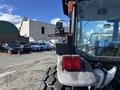 A 2010 New Holland T4050 tractor with a rear view showing its taillights and part of the cabin interior visible through the window