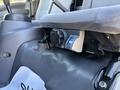 The interior adjustment control for a 2016 Isuzu NPR-HD truck seat showing a blue indicator dial and a textured gray fabric seat cushion