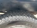 Close-up of a tire from a 2010 Suzuki Carry displaying a tread pattern with a label on the sidewall indicating the brand and model