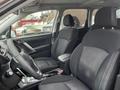 Interior view of a 2016 Subaru Forester featuring black fabric seats and a steering wheel with control buttons visible