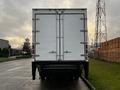 A 2017 Hino 338 box truck viewed from the rear with a plain white cargo box and multiple vertical metal latches on the doors