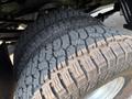Close-up of two all-terrain tires mounted on a 2021 Ford F-350 SD showcasing a rugged tread pattern designed for off-road performance