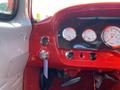 Interior dashboard of a 1962 Ford 2WHDR featuring red tones carbon fiber accents and three round gauge dials for voltage RPM and oil pressure with a key ignition mechanism