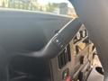 A close-up of a steering wheel control lever in a 2020 Chevrolet Express featuring a "+" and "-" button for adjusting settings
