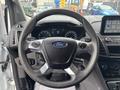Steering wheel of a 2019 Ford Transit Connect with the Ford logo and control buttons visible on the side