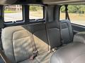 Interior view of the back seat of a 2021 Chevrolet Express with gray leather upholstery and seat belts visible