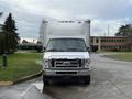 A white 2022 Ford E-450 box truck is parked facing forward with a large cargo area and a chrome grille