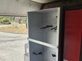 Interior view of a 2011 Workhorse W62 with an empty metallic cabinet featuring hooks and brackets for storage