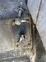 A close-up view of a metal switch assembly attached to a surface with a bolt and a washer visible alongside it