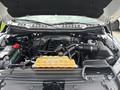 The engine compartment of a 2017 Ford F-150 featuring a large black engine cover and yellow coolant reservoir with visible battery and other components