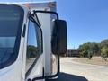 A 2022 Isuzu NRR truck showing the side mirror and part of the cab with a clear view of the exterior features