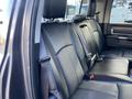 The interior of a 2017 RAM 1500 showing black leather rear seats with headrests and seatbelts attached