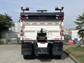 A white 2013 International WorkStar truck viewed from the rear with lights and reflectors on the roof and a mechanical component attached to the back