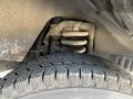 Close-up view of a 2012 Ford Econoline's suspension system and tire showcasing the coil spring and tread pattern on the tire