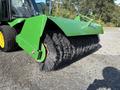 A green brush attachment for a 2021 John Deere 1575 featuring thick black bristles designed for sweeping surfaces