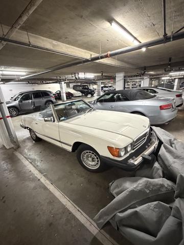 White 1982 Mercedes-Benz 380 convertible parked in a garage with its top down