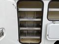 Interior storage compartment of a 2008 Ford F-550 with metal shelving units arranged vertically