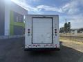 Rear view of a 2012 Ford Econoline with a white cargo box and red tail lights